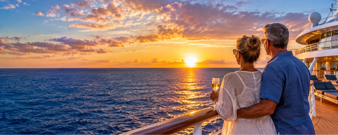 A couple watching the sunset from the deck of a cruise ship