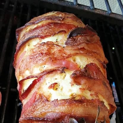 The finished Swineapple on the grill — a pineapple wrapped in bacon cooked crisp and deep golden brown